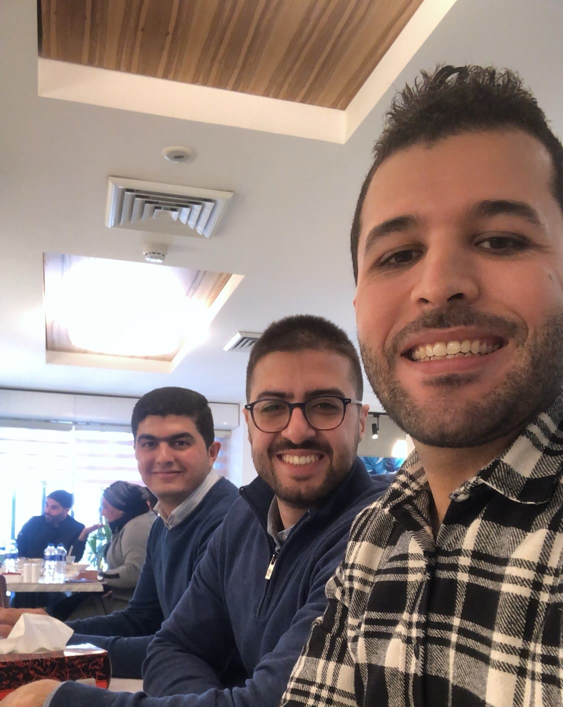 A selfie in a restaurant: Nael, Maisara, and Bahzad.